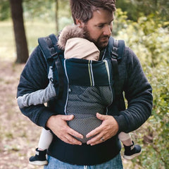 A dad taking a walk with his child carried in a Bambino Air