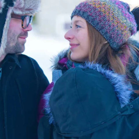 A couple taking a walk and their baby kept him warm and safe in a Babygloo baby cover.