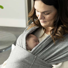 Une maman en portage avec l’écharpe Snug, l’accessoire parfait pour prolonger les bienfaits du peau à peau une fois que bébé grandit.