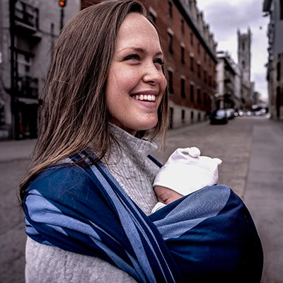 A parent carries their newborn using the traditional woven baby wrap from Chimparoo.