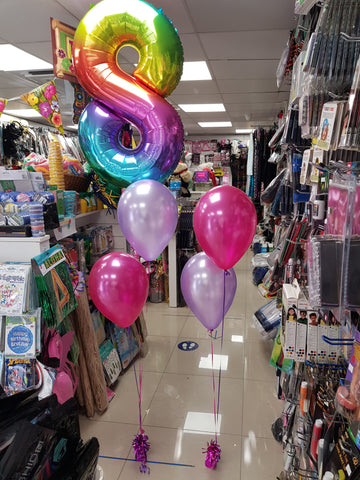 Two balloon bouquets with rainbow number eight balloon