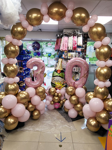 Pastel matte pink and chrome gold 30th birthday deluxe air-filled arch, balloon columns and themed balloon stack