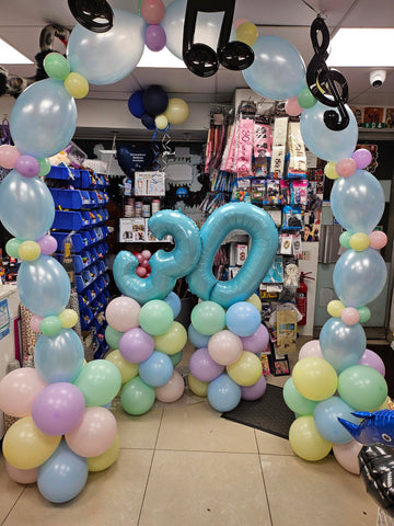 Pastel 30th birthday number balloon columns and deluxe air-filled arch