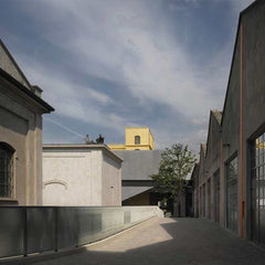 golden building in the foreground separating a road of buildings on either side, light blue sky