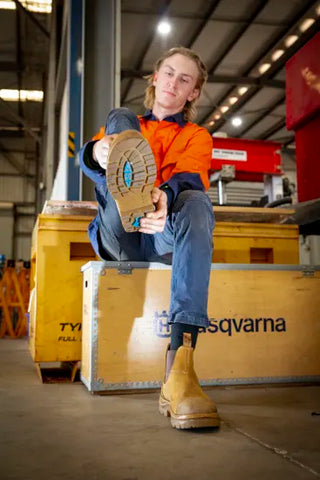 worker pulling on hobart scuff cap safety boots