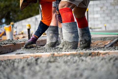 tradie working in concrete with gumboots on