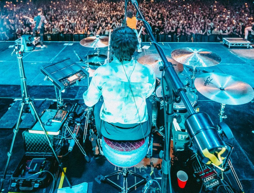Don Broco drummer, Matt Donnelly at his drum kit, on an arena stage in front of a crowd