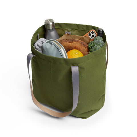 Bellroy's Market Tote in Ranger Green fabric, filled with a loaf of bread, a water bottle and lots of veggies