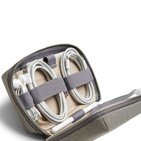 Bellroy Tech Carry Kit | Milligram [img: a Bellroy Tech Carry Kit sat open, revealing neatly strapped cables, headphones, and more inside the grey rectangular case]