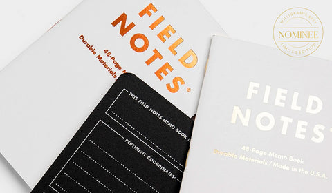 Field Notes Group Eleven notebooks, featuring white covers with the Field Notes logo in silver and copper