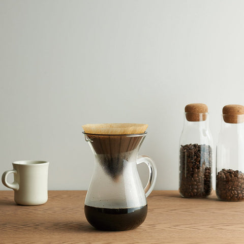 Kinto Slow Coffee Style Carafe Set sat on a bench with a full pot brewed
