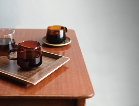 Kinto Sepia glassware on a wooden tray, sat on a wooden table