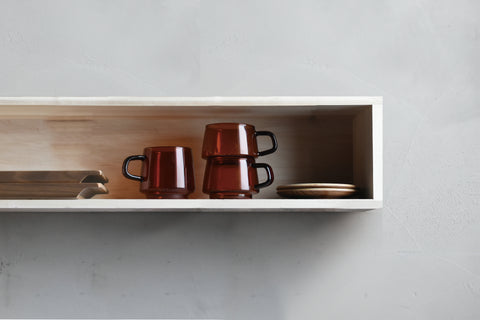 Kinto Sepia cups on a kitchen shelf next to some crockery