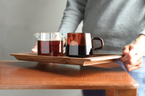 A Kinto Sepia Jug on a wooden tray