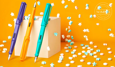 LAMY safari candy special edition fountain pens in Violet, Mango and Aquamarine stood on a yellow background with confetti