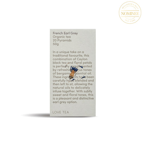 Love Tea French Early Grey Tea, in a soft stone-coloured rectangular box with dense black type with an image of a dried cornflower blossom superimposed