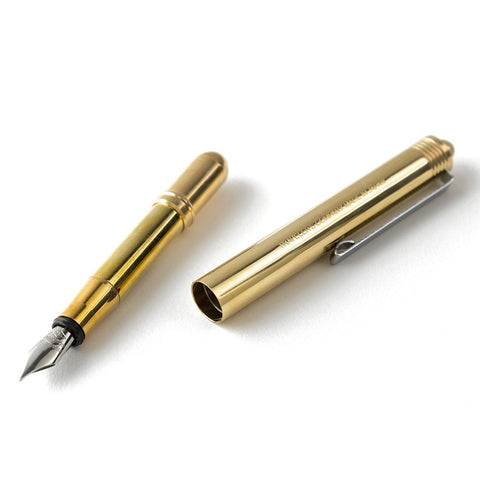 Traveler's Company Brass Fountain Pen laid with its cap off on a white surface
