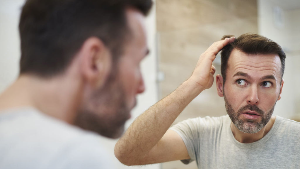 DHEA hair loss guy worried in front of mirror