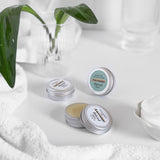 Nail & Cuticle Balm and Minty Mayhem Lip Balm in the Bathroom with white towel, cotton wool & Plant