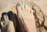 Blue toe nails in the sand