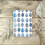 Patterned note book with leaves and pen on side