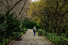 Women walks in the park, with trees and benches