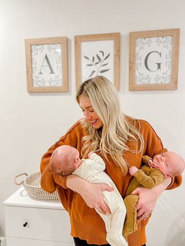 woman with infant twin babies in nursery room 