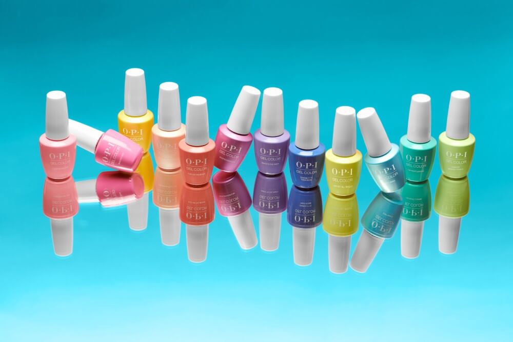 Twelve colorful OPI gel polish bottles lined up unevenly on a reflective surface