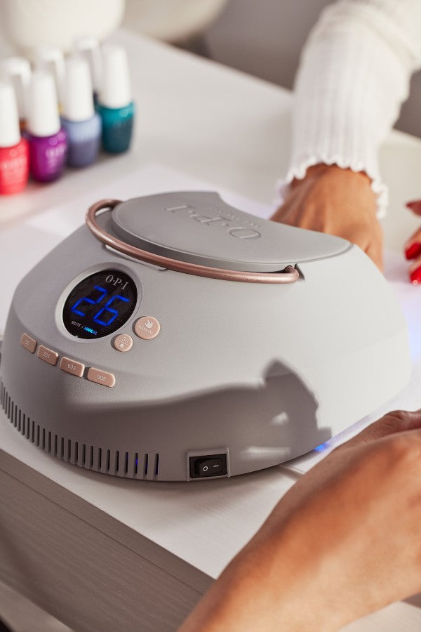 Person putting their hand in an LED lamp to cure their nails