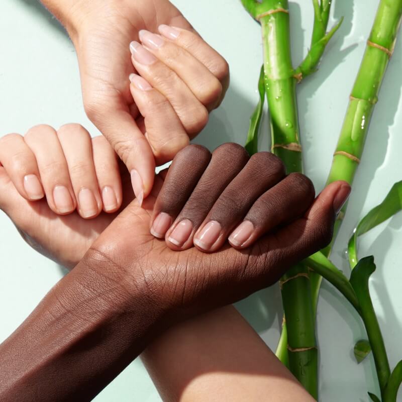 three hands show natural strong nails next to bamboo