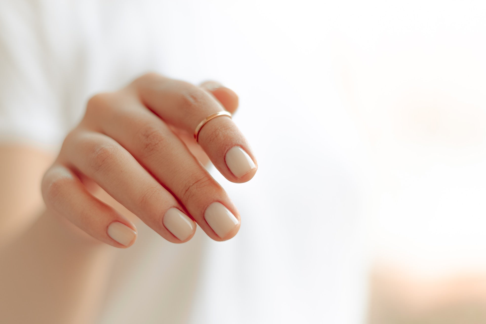Hands With Pale Nude Nails and Dainty Ring