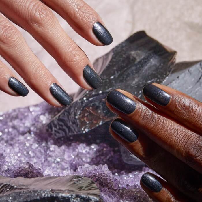 Two hands with shimmery dark grey nails