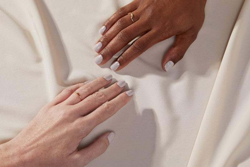 Two hands on tablecloth showing taupe nails