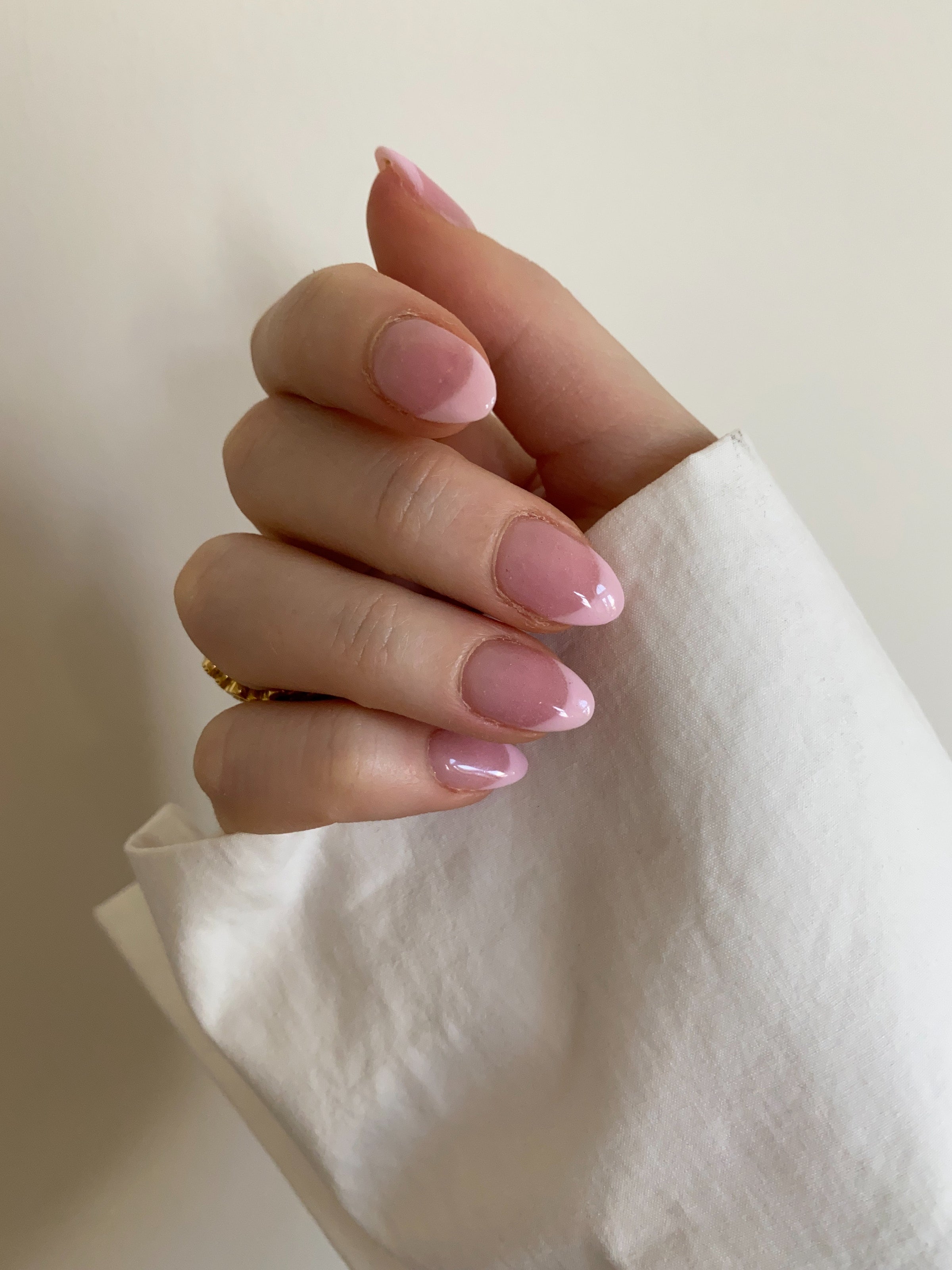 Hand in a loose fist showing semi transparent pink nails