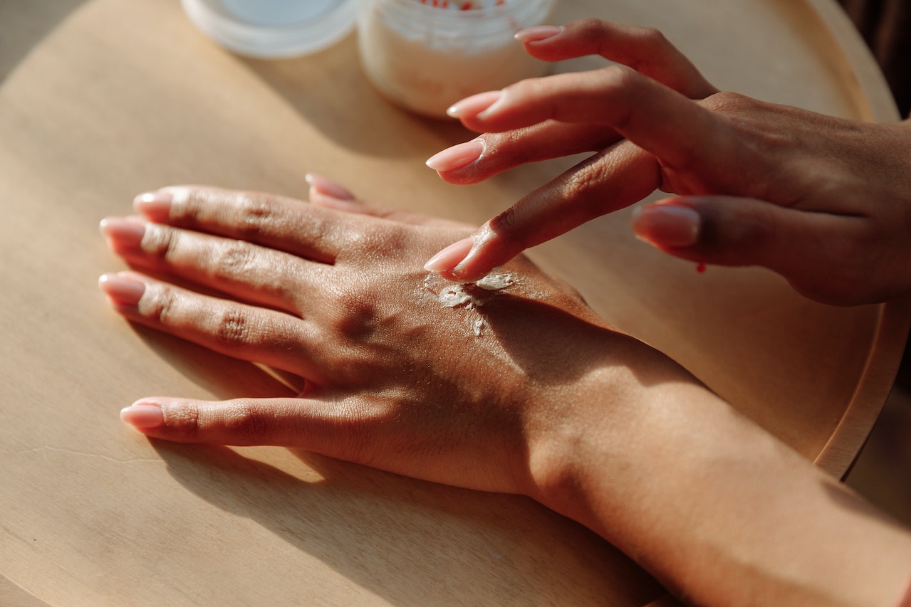 Person Applying Moisturizing Cream to Hands