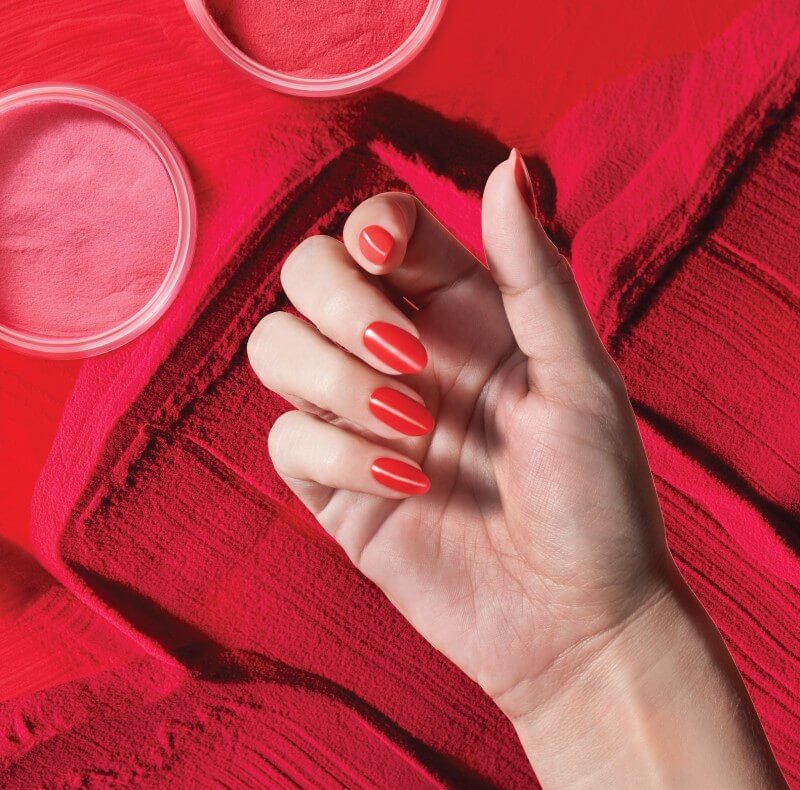 hand with red nails over red powder