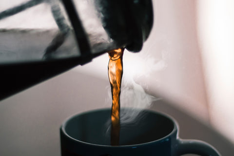 french press pouring coffee to a cup