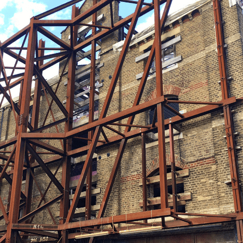 urban scaffold support against old building facade