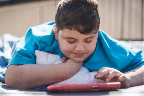 A child playing on a table while laying on a trampoline mat.