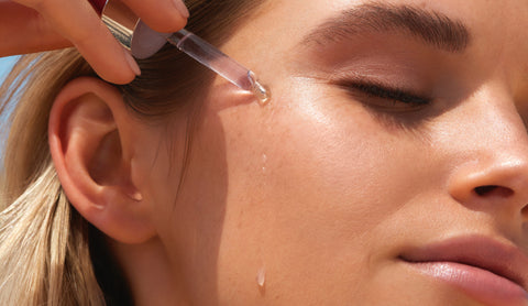 girl applying dreamy glow drops to her face