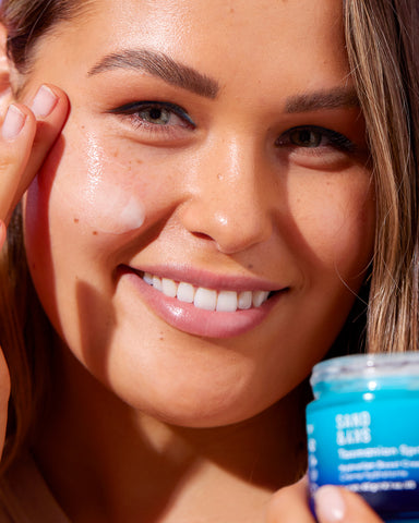 girl applying sand and sky product to face