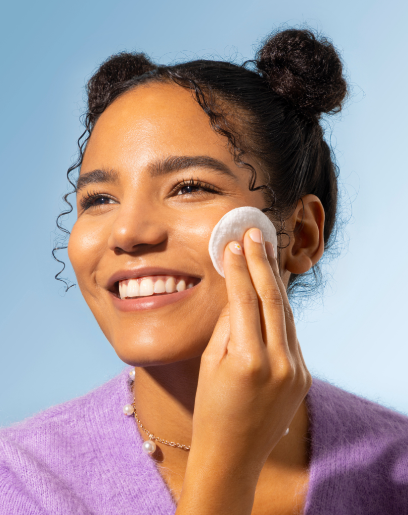 girl applying toner with cotton pad