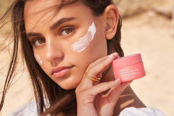 girl holding jar of pink clay mask