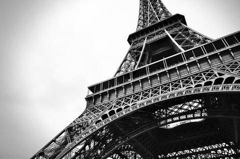 A black and white image of the Eiffel Tower in Paris from the ground.