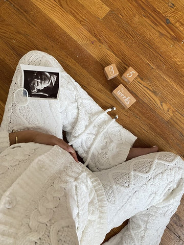 Pregnant woman sitting with ultrasound photo