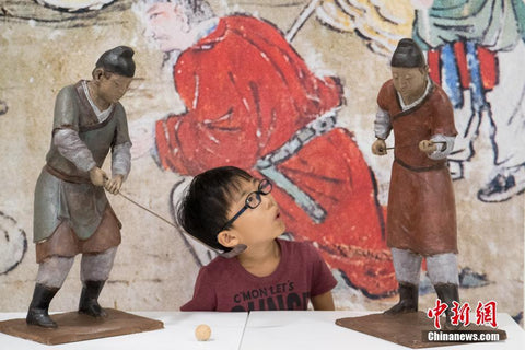 A young visitor in sculptures exhibition ‘Sports from Ancient Murals’ in Shanxi Province, China, 2019