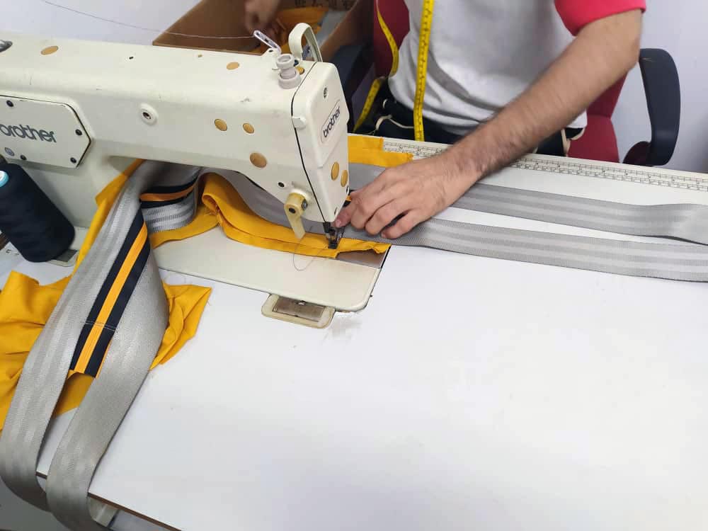 Small production of eKodoKi RE-BELT backpacks, made of discarded seatbelts. A single eKodoKi bag can take up to 4 days to produce – crafted by a small group of skilled tailors deserving of fair wages.