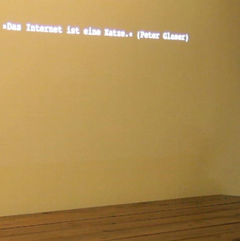 An die Wand projizierter Text: »Das Internet ist eine Katze.« (Peter Glaser)