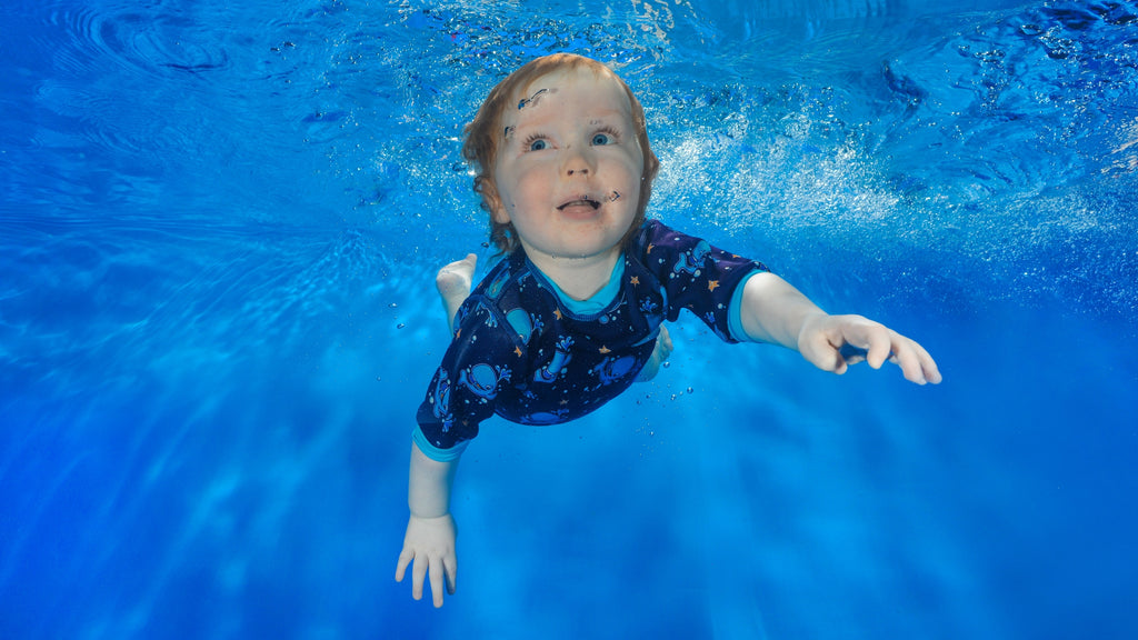 Underwater photo of toddler wearing a Happy Nappy wet suit.