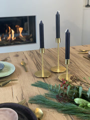 kersttafel met gouden kandelaars en zwarte kaarsen
